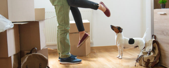 Happy man lifting woman in new house